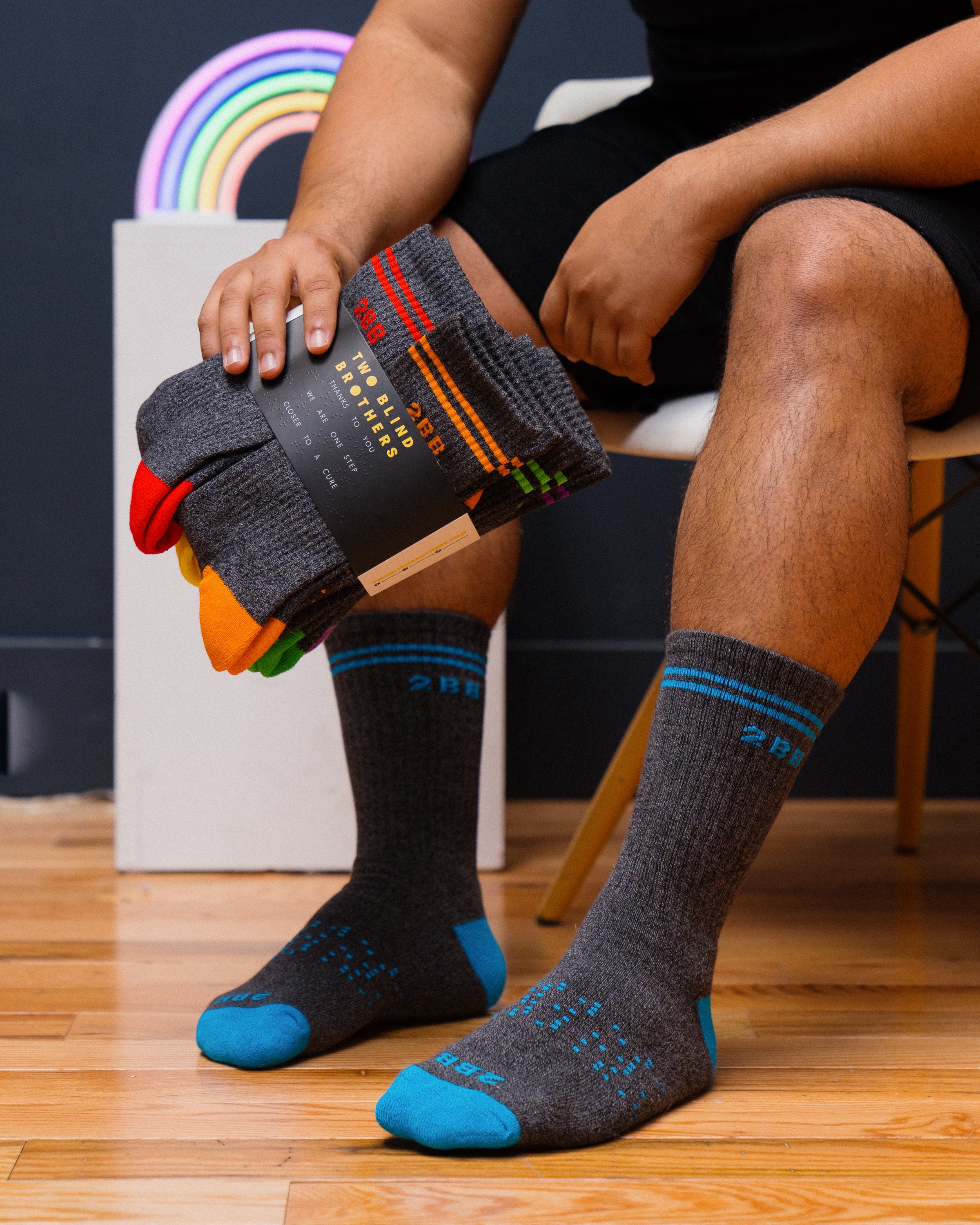 Model wearing blue calf socks holding six pack of calf socks